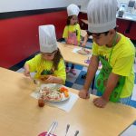 Children cooking with chef hats and aprons.